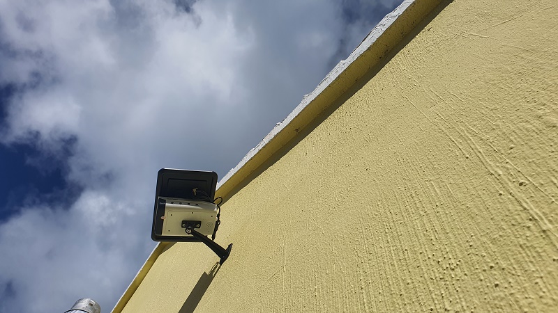 Solar powered wireless surveillance camera installed under the roof of warehouse